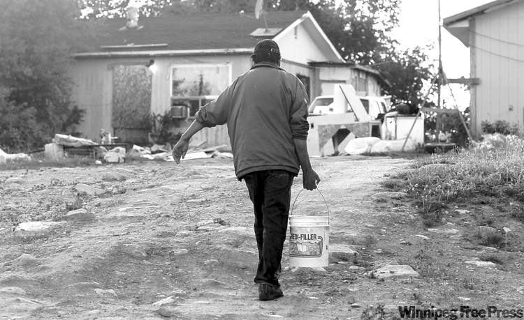 JOE BRYKSA / WINNIPEG FREE PRESS ARCHIVES
A man hauls lake water at Red Sucker Lake First Nation. Ottawa and aboriginal leaders are hoping such scenes become less common in northern communities.