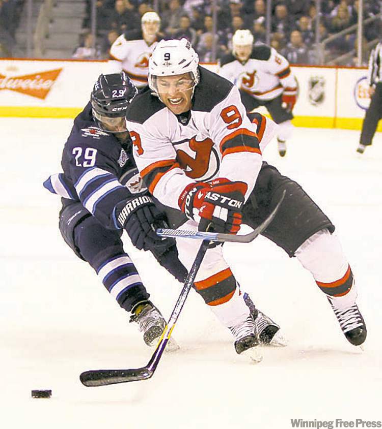 Jets' Johnny Oduya tries to keep Devils' Dainius Zubrus off the disc in the contest Saturday.