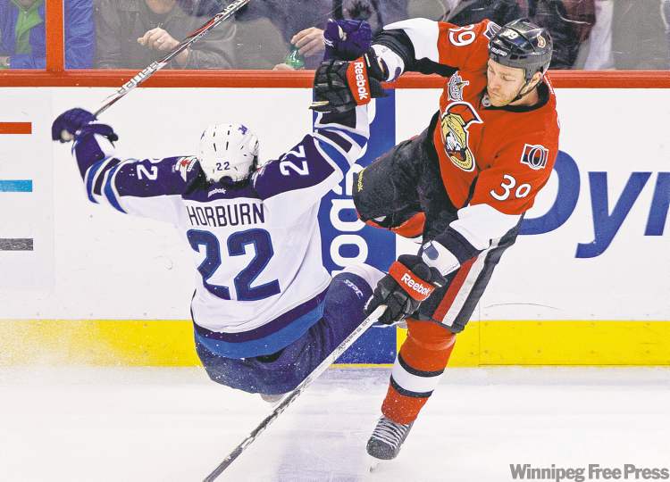 Adrian Wyld / The Canadian Press
Ottawa's Matt Carkner sends Winnipeg Jet Chris Thorburn flying during second-period action Monday night in Ottawa.