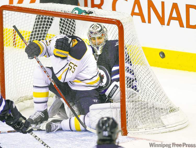 Phil Hossack / Winnipeg Free Press
The Sabres' Jochen Hecht covers up after finding himself the target of his own team inside the Jets net with goalie Ondrej Pavelec in second-period action Thursday.