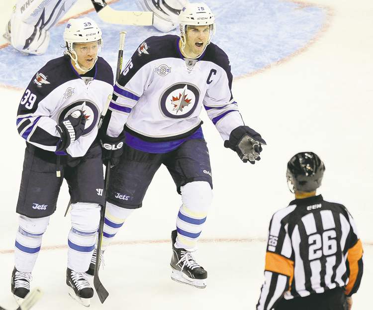 Chuck Myers / MCT
Jets blue-liner Tobias Enstrom (39) and captain Andrew Ladd protest a slashing penalty on Enstrom by referee Rob Martell Thursday night.