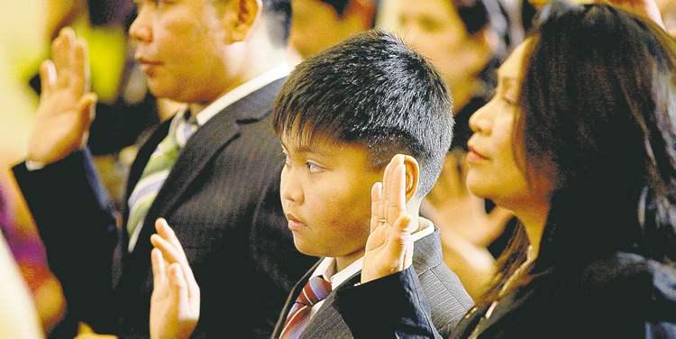 KEN GIGLIOTTI / WINNIPEG FREE PRESS
Daryl Boado, 10, takes his oath of Canadian citizenship with his father, Melchor, and mother, Natividad, on Tuesday.