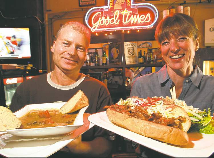 Winnipeg Free Press
BORIS MINKEVICH / WINNIPEG FREE PRESS
Yellow Dog bar manager Greg Ash, left, and owner Michelle Chabot with beef-and-Guinness stew and pulled-pork sandwich.