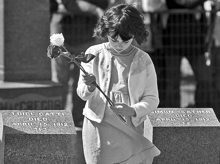 CP
Andrew Vaughan / The Canadian Press
A child holds a flower to place on a grave marker at the memorial service at Fairview Lawn Cemetery in Halifax Sunday.