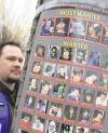 LYLE STAFFORD / Postmedia News Archives
A police officer in Victoria, B.C. puts up posters of some  of the Vancouver hockey riot suspects.