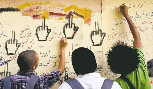 PETE MULLER / THE ASSOCIATED PRESS ARCHIVES
Youth activists write on a wall in Tahrir Square, Cairo, earlier this week.