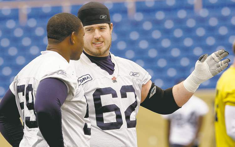 ken gigliotti / winnipeg free press
The last hog standing, Blue Bomber guard Steve Morley (62) gives a few pointers to tackle Andre Douglas at Monday�s workout.