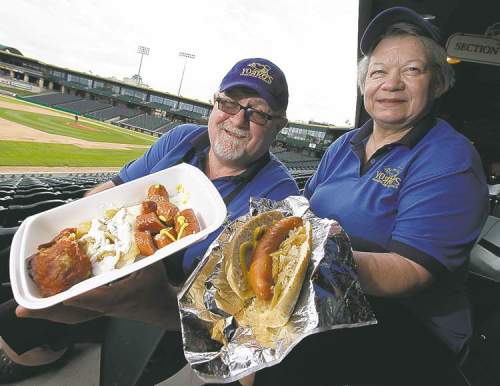 JOHN WOODS / WINNIPEG FREE PRESS
Rick and Maryanne Jones show off a Baba’s Special and a Ukrainian hotdog — two big hits at Shaw Park.