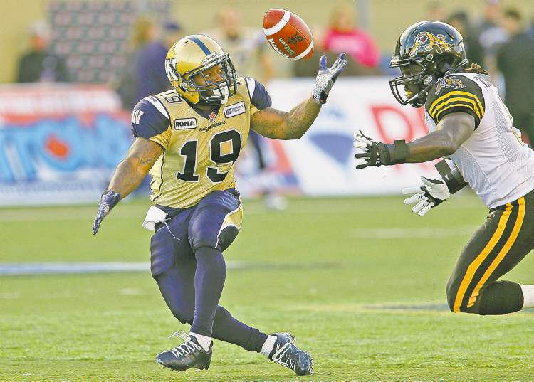 John Woods / The Canadian Press
The Blue Bombers' Chris Garrett (left) bobbles a pass as the Tiger-Cats' Renauld Willams pursues during first-half action Wednesday.