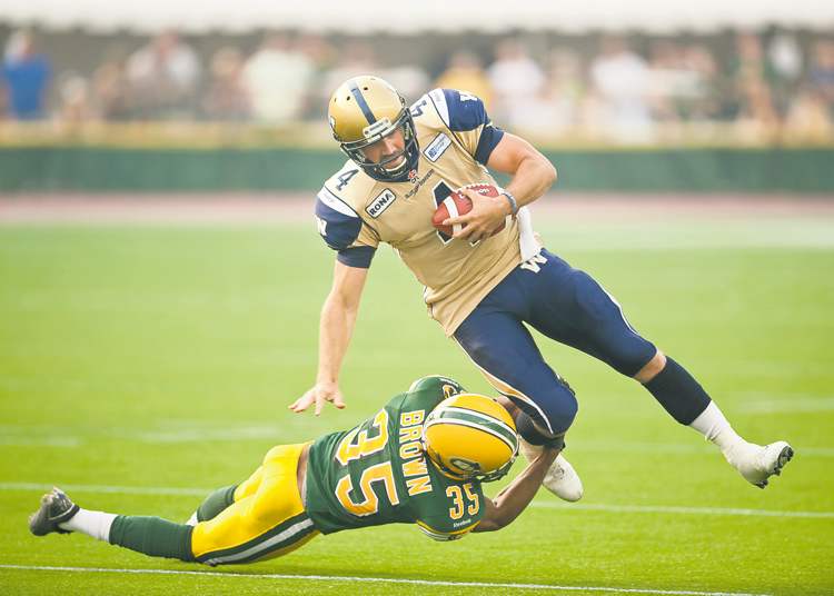CP
photos by john ulan / the canadian press
Edmonton�s Weldon Brown brings down Winnipeg Blue Bombers quarterback Buck Pierce Friday night at Commonwealth Stadium.
