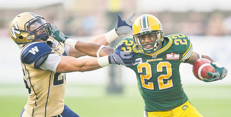 CP
Edmonton�s Joe Burnett (right) gives the straight-arm to Blue Bomber Brady Browne in the second quarter.