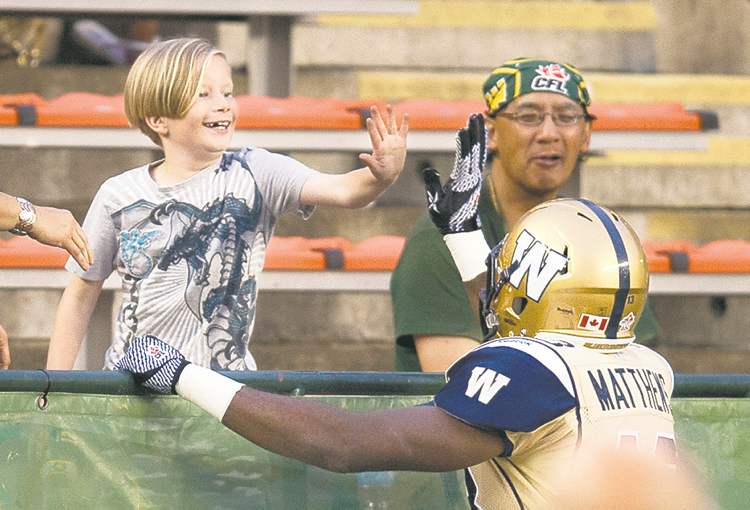 john ulan / the canadian press
Bombers receiver Chris Matthews makes a young fan happy after scoring a touchdown against the Eskimos.