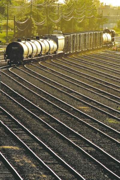 Mike Deal / Winnipeg Free Press
The sun set casts a warm glow as a lone rail yard employee accompanies some rail cars as they move through the CP Rail yards.