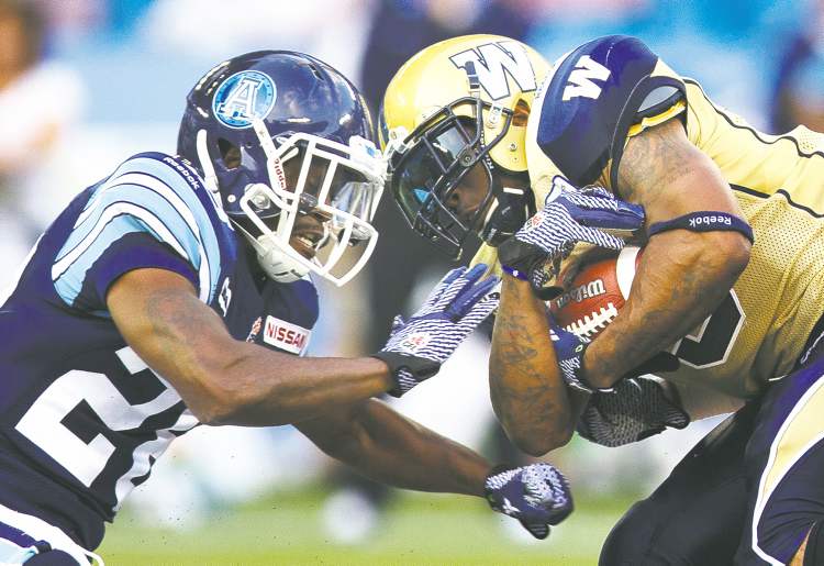 REUTERS
Mark Blinch / REUTERS
Bombers� Chad Simpson protects the ball Wednesday as Argonauts� Jordan Younger goes for it. Simpson chalked up 91 yards on 15 carries despite extended time on the sideline due to injury.