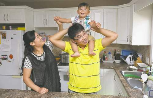 Colin Corneau / Brandon Sun 
Jerry Jiang and his wife, Yuyan Liu, play with their 16-month-old son Ethan. When Jiang first came to Manitoba in 2008 to work at Maple Leaf Foods in Brandon, he only planned to stay for two years.