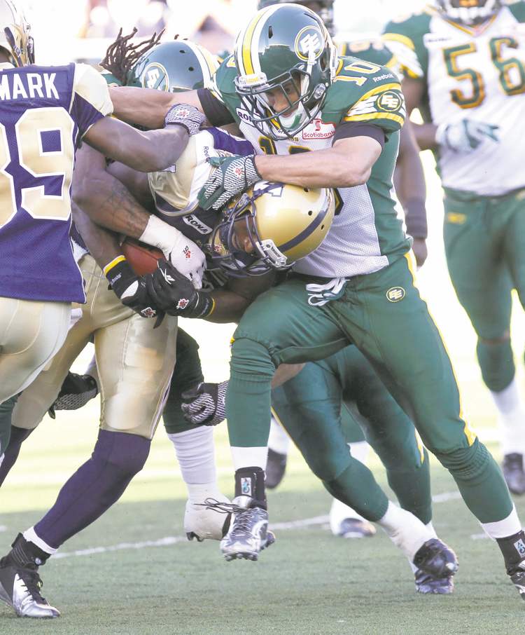 MIKE DEAL / WINNIPEG FREE PRESS archives
Bombers' Cory Watson tries to break the tackle of Edmonton's Donovan Alexander (10) during Thursday's game at Canad Inns Stadium.