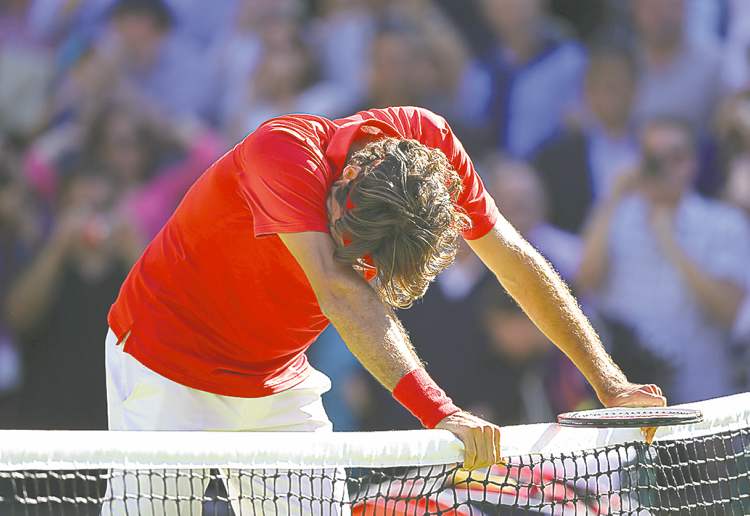 Tribune Media MCT
Robert Gauthier / Los Angeles Times / MCT
An exhausted Roger Federer leans on the net after beating Juan Martin Del Potro.