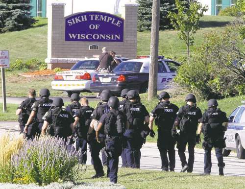CP
Jeffrey Phelps / The Associated Press archives Police walk near the Sikh temple in Oak Creek, Wis., after the deadly shootings on Aug. 5.