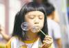 Trevor Hagan / Winnipeg Free Press
Kitty Lu, 6, blows bubbles while waiting for the Lion Dance to begin in Chinatown on Saturday.