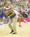 Tribune Media MCT
Harry E. Walker / MCT
Angel McCoughtry tackles unsuspecting U.S. coach Geno Auriemma after defeating France for basketball gold.