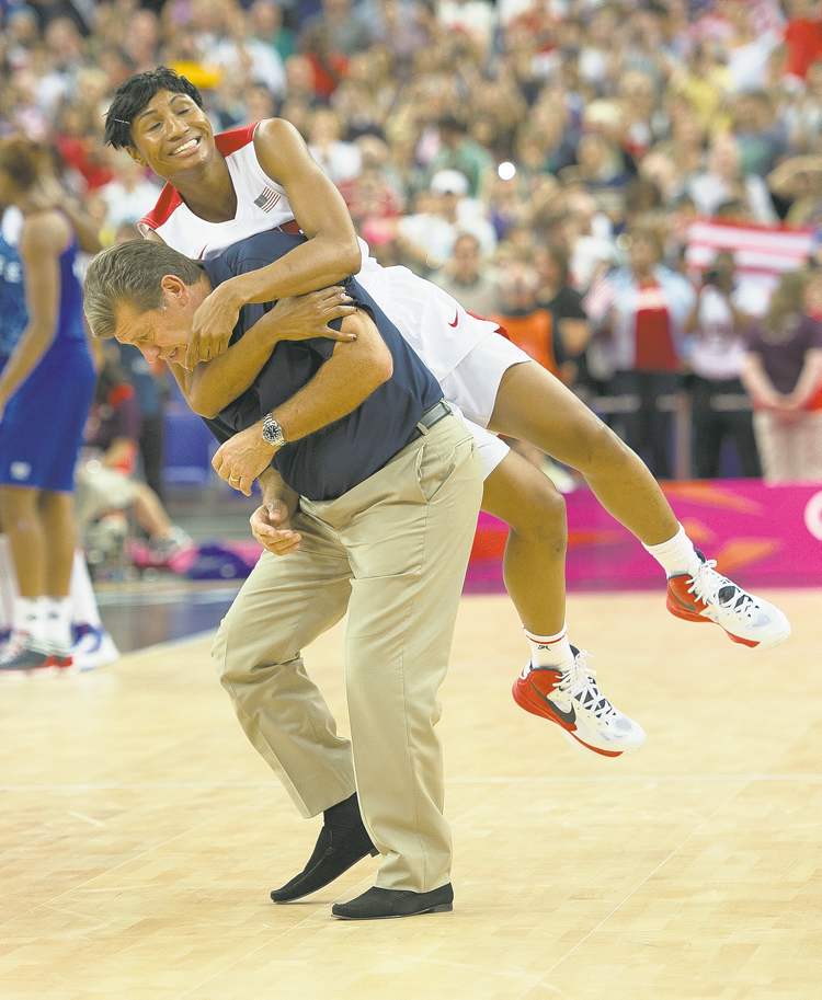 Tribune Media MCT
Harry E. Walker / MCT
Angel McCoughtry tackles unsuspecting U.S. coach Geno Auriemma after defeating France for basketball gold.
