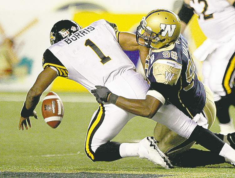 Winnipeg�s Alex Hall takes down Hamilton�s Henry Burris in the fourth quarter.