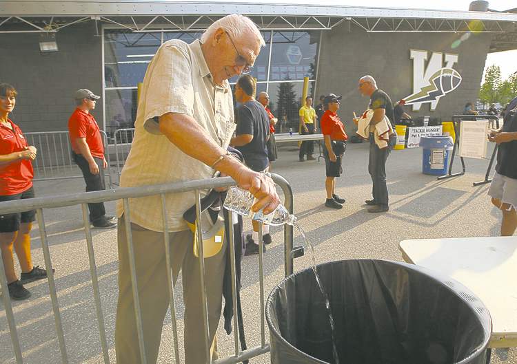 Bomber fan Ed Langlois dumps his bottled water at security check as he arrives at Canad Inns Stadium Friday night.