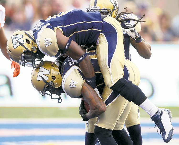 joe bryksa / winnipeg free press
Winnipeg Blue Bombers' DB Johnny Sears (bottom) is congratulated by gleeful teammate Brandon Stewart after Sears picked off a first-quarter pass.