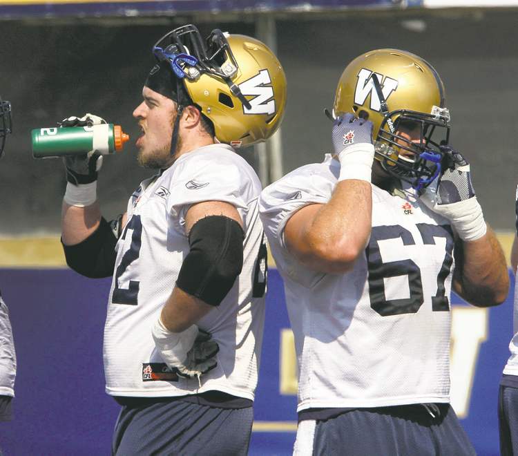 JOE BRYKSA / WINNIPEG FREE PRESS
Winnipeg offensive linemen Steve Morley (left) and Chris Kowalczuk take a brief breather during practice Tuesday at Canad Inns Stadium.