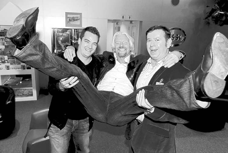 Winnipeg Free Press
Sir Richard Branson is hoisted by Virgin Radio Winnipeg Brand Director Dale Davies and Virgin Radio Canada�s Executive VP of Content Programming Rob Farina upon his arrival in Winnipeg. Photo taken at Esso Avitat where all the private jets land. He�s in town for some charity event. October 4th, 2012 BORIS MINKEVICH / WINNIPEG FREE PRESS