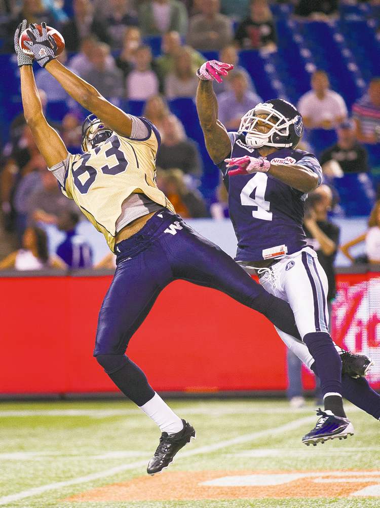 Nathan Denette / The Canadian Press
Blue Bombers wide receiver Doug Pierce makes a spectacular grab, eluding Argonauts defensive back Pacino Horne.