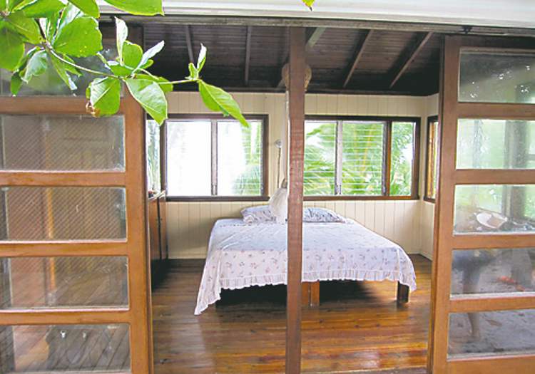 MCT
Sliding teak-wood doors open Sandy Cay's master bedroom to catch the Caribbean breeze in Sandy Cay, off Honduras.