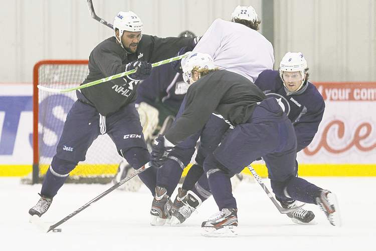 CP
John Woods / THE CANADIAN PRESS
Jets defenceman Dustin Byfuglien (left) drives teammate Chris Thorburn (centre) into Ron Hainsey (right) as Bryan Little (back) carries the puck during a Wednesday workout.