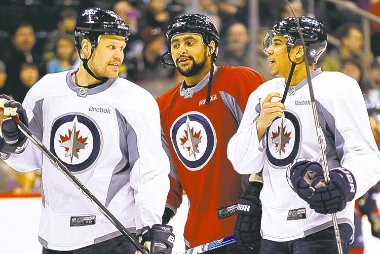 John Woods / The Canadian Press
Kane chats with teammates Olli Jokinen (left) and Dustin Byfuglien during the public practice session.