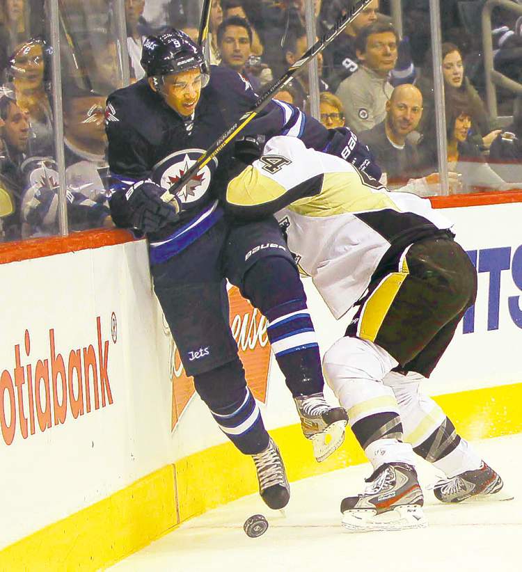 BORIS MINKEVICH / WINNIPEG FREE PRESS
Evander Kane takes a hit from Penguin blue-liner Brooks Orpik.