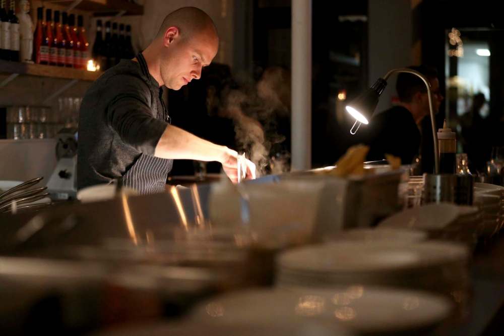 TREVOR HAGAN / WINNIPEG FREE PRESS
Chef de Cuisine, Aaron Dreger-Sitar, preparing Pan Fried Greens with XO Sauce