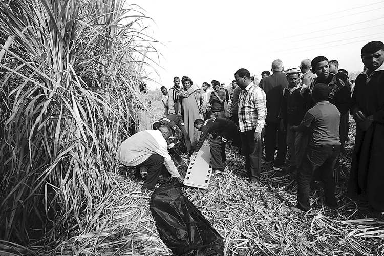 CP
Hagag Salama / The Associated Press
Rescue workers remove a body from the scene of a balloon crash just west of the city of Luxor, Egypt Tuesday. A hot air balloon caught fire and crashed into a sugar cane field, killing 19.