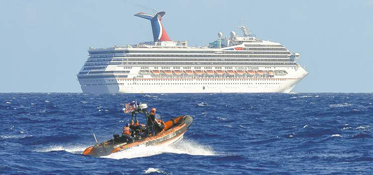 CP
In this image released by the U.S. Coast Guard on Feb. 11, 2013, a small boat belonging to the Coast Guard Cutter Vigorous patrols near the cruise ship Carnival Triumph in the Gulf of Mexico, Feb. 11, 2013. The Carnival Triumph has been floating aimlessly about 150 miles off the Yucatan Peninsula since a fire erupted in the aft engine room early Sunday, knocking out the ship's propulsion system. No one was injured and the fire was extinguished. (AP Photo/U.S. Coast Guard- Lt. Cmdr. Paul McConnell)