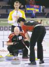 CP
Manitoba skip Jeff Stoughton  watches as Ontario skip Glenn  Howard barks orders at sweeper Craig Savill on Sunday night.