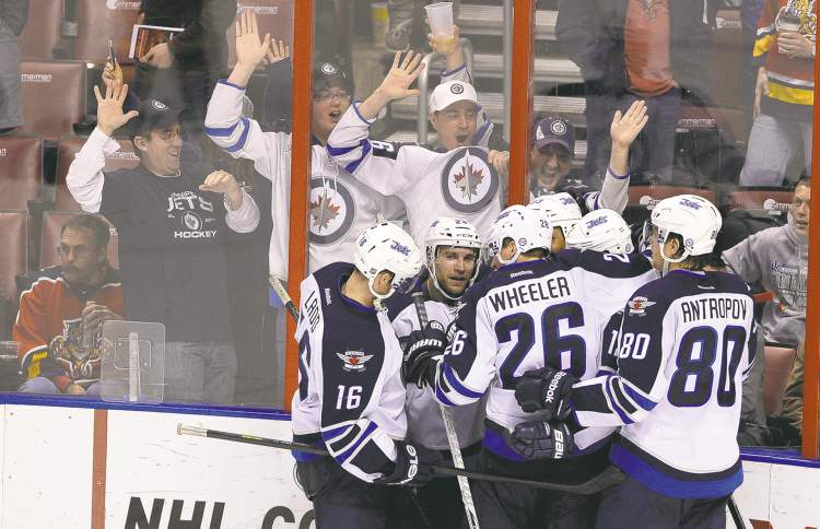 REUTERS
It was worth the trip: Winnipeg Jets fans celebrate their team's overtime win against the Florida Panthers on Friday night. A Panthers fan tries to ignore the interlopers.