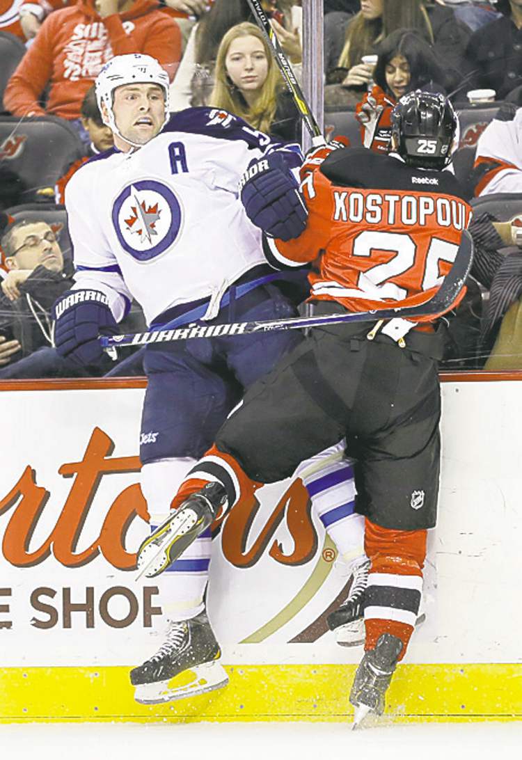 mel evans / the associated press
Winnipeg Jets' Mark Stuart and New Jersey Devils' Tom Kostopoulos collide in the first period.
