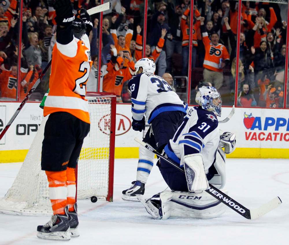 Tom Mihalek / The Associated Press
With the game-winning goal in the net Philadelphia Flyers' Claude Giroux, left, raises his arms after scoring past Winnipeg Jets' Ondrej Pavelec, right, during the overtime period of an NHL hockey game Monday, March 28, 2016 in Philadelphia. The Flyers won 3-2.