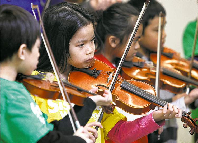 Mike Deal / Winnipeg Free Press
Elwick Community School student, AJ Rosaldo (second from left), 8, plays her violin along with about 30 other students who are part of the Sistema after-school program.