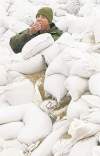 Jonathan Hayward / The Canadian Press archives
A soldier takes a break from  sandbagging duties in 2011.