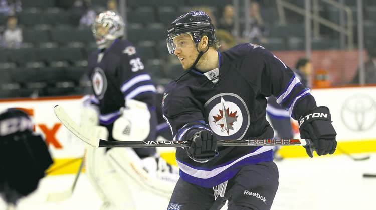 Bryan Little warms up with the team Thursday at the MTS Centre. His numbers show the Jets centreman is proving his worth.
