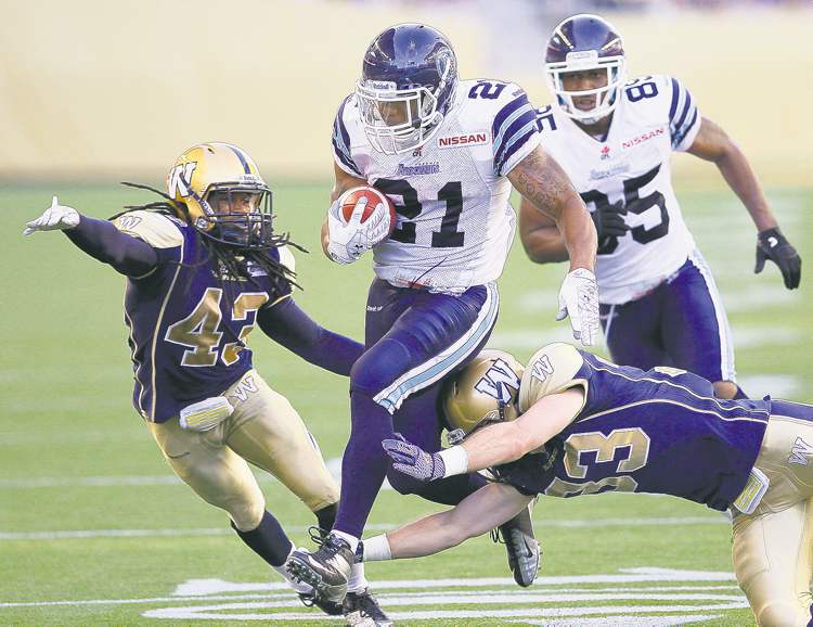 John Woods / the canadian press
Gerald Riggs Jr. carries the ball in for a T.O. touchdown despite the best efforts of Bombers Marty Markett (43) and Dan West (33). There weren't many reasons for the home fans to cheer -- but the stadium sounded pretty good when they did.