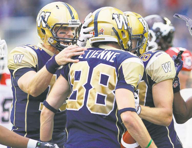 CP
John Woods / the canadian press
Quarterback Justin Goltz congratulates Jade Etienne on his touchdown against the Calgary Stampeders Friday night at Investors Group Field.