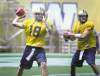 Phil Hossack / Winnipeg Free Press 
New No. 1 quarterback Justin Goltz (18) and new No. 3 QB Buck Pierce, formerly No. 1, toss footballs Friday at practice as they prepare for Monday's game against the B.C. Lions in Vancouver.