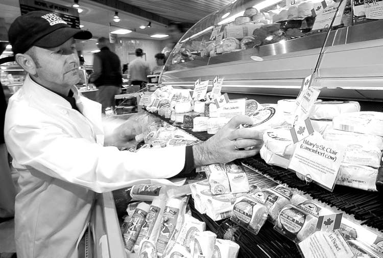 Vancouver Sun
postmedia NEWS
Kevin Keane stocks the cheese shelves at the recently opened Whole Foods Market in West Vancouver.