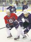 Wayne Glowacki / Winnipeg Free Press
Defenceman Ian White (left) battles Patrice Cormier for the puck on the opening day of training camp Thursday.
